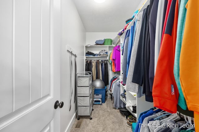 walk in closet featuring light carpet