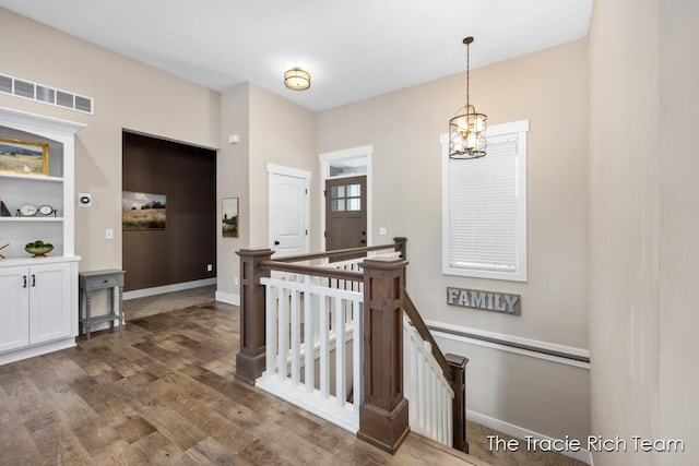 hall with a chandelier and dark hardwood / wood-style flooring