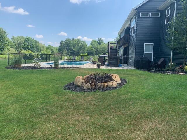 view of yard with a fenced in pool and a fire pit