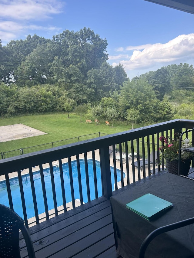 wooden terrace with a yard and a fenced in pool