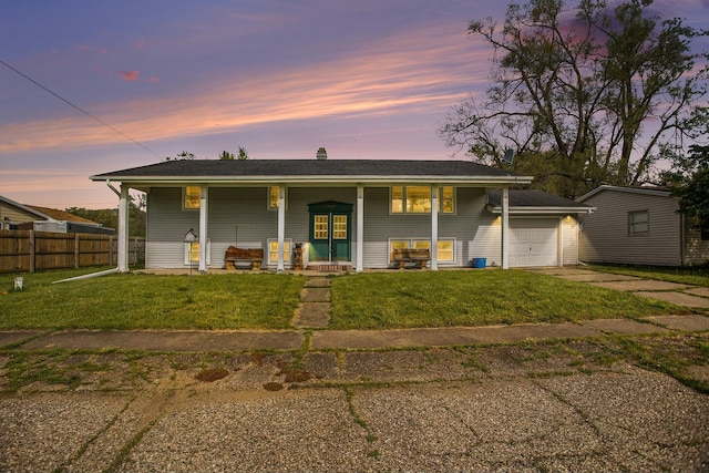 back house at dusk with a garage, a lawn, and a porch