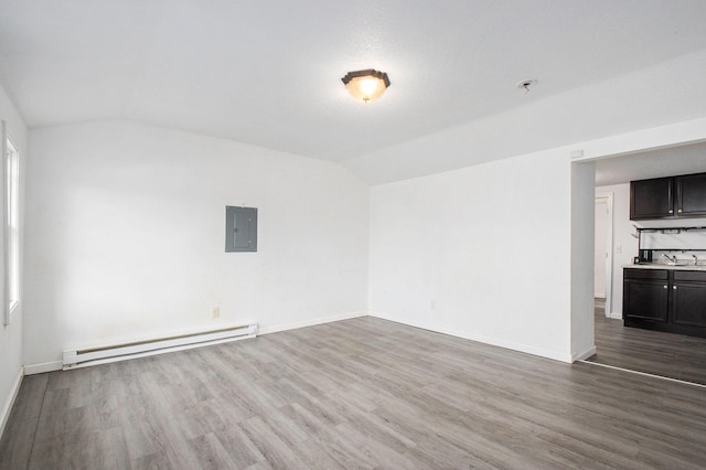 empty room with electric panel, dark hardwood / wood-style floors, vaulted ceiling, and baseboard heating