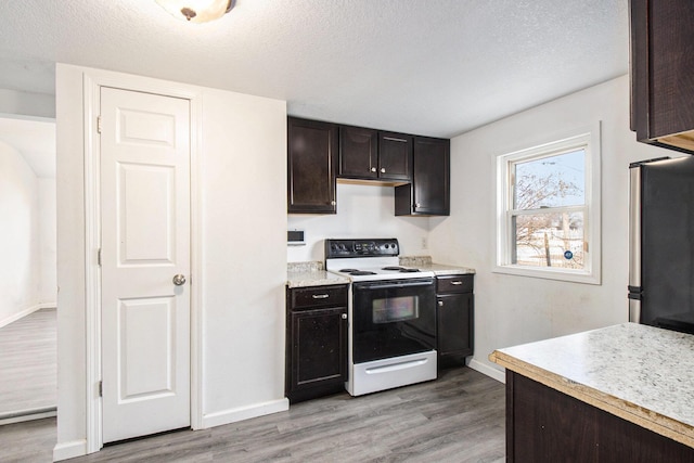 kitchen featuring white electric stove, light wood-type flooring, a textured ceiling, dark brown cabinets, and stainless steel refrigerator