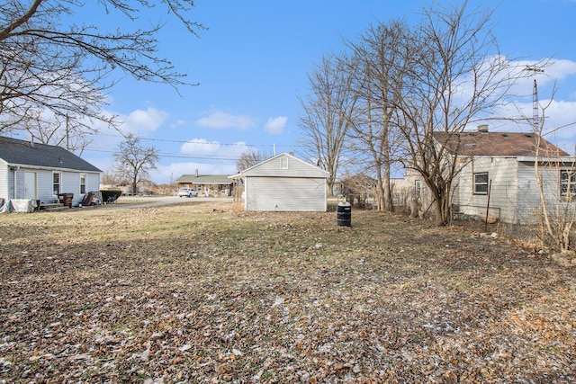 view of yard with a garage and an outbuilding