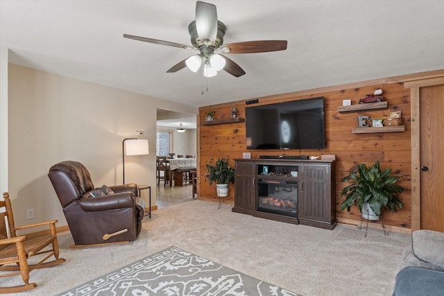 living room with light colored carpet, ceiling fan, and wooden walls