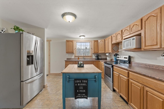 kitchen with a kitchen island, stainless steel appliances, and sink