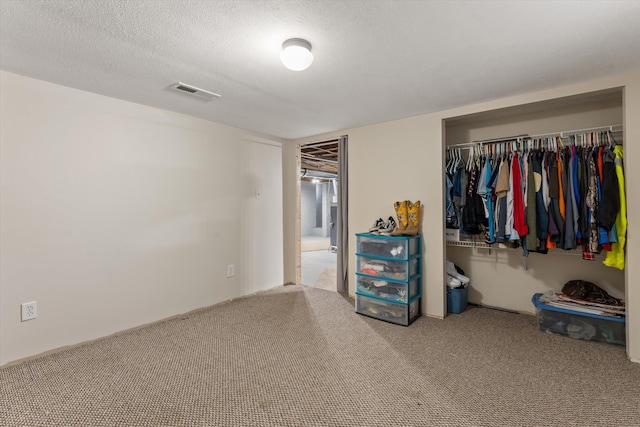 unfurnished bedroom with a textured ceiling, a closet, and carpet floors