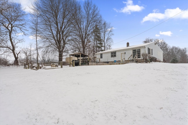 view of snow covered back of property