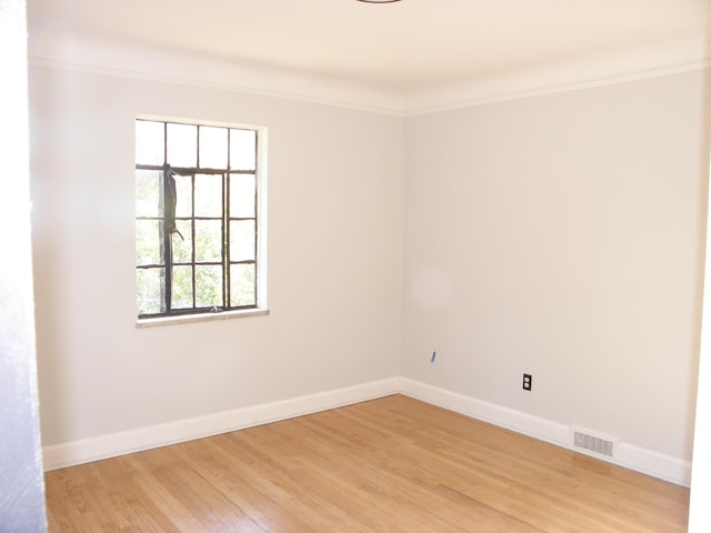 empty room with light hardwood / wood-style flooring and ornamental molding