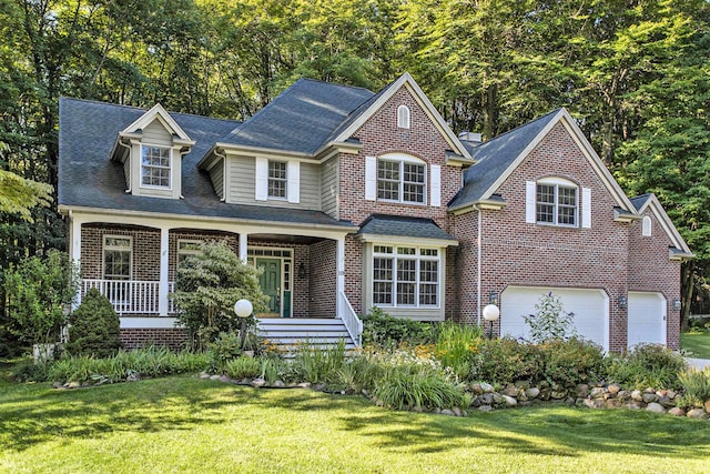 view of front of home with a front yard, a porch, and a garage