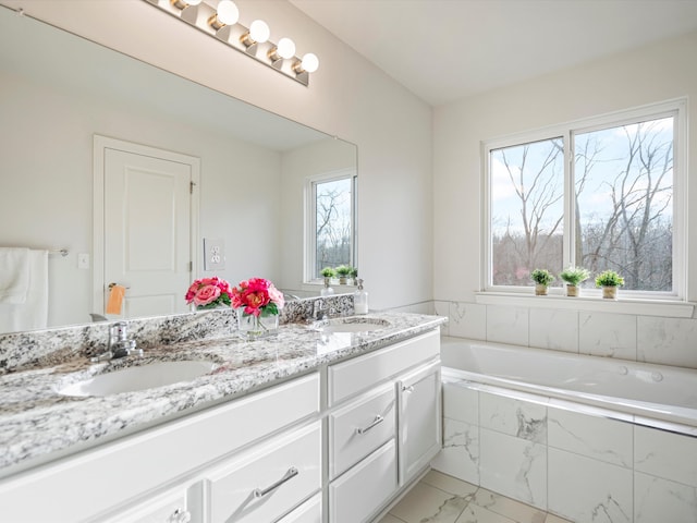 bathroom with vanity and tiled bath