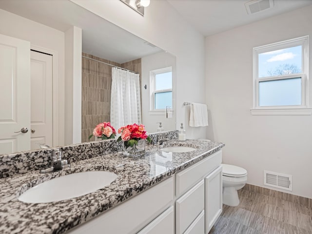 bathroom with a shower with shower curtain, vanity, and toilet