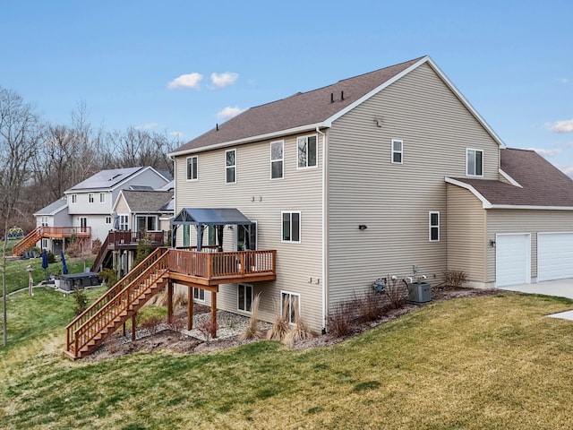 rear view of house featuring central air condition unit, a wooden deck, a lawn, and a garage