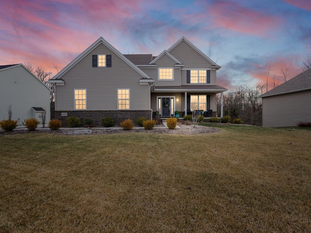 front facade featuring a yard and covered porch