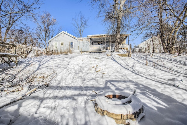 snow covered house with an outdoor fire pit