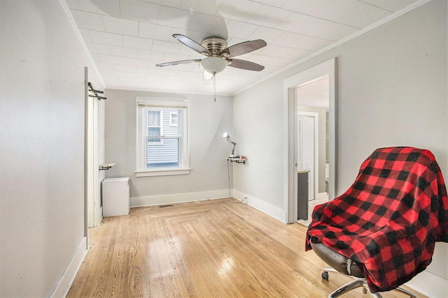 living area featuring crown molding, ceiling fan, and light hardwood / wood-style flooring