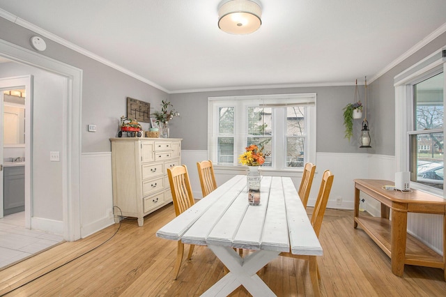 dining room with crown molding and light wood-type flooring