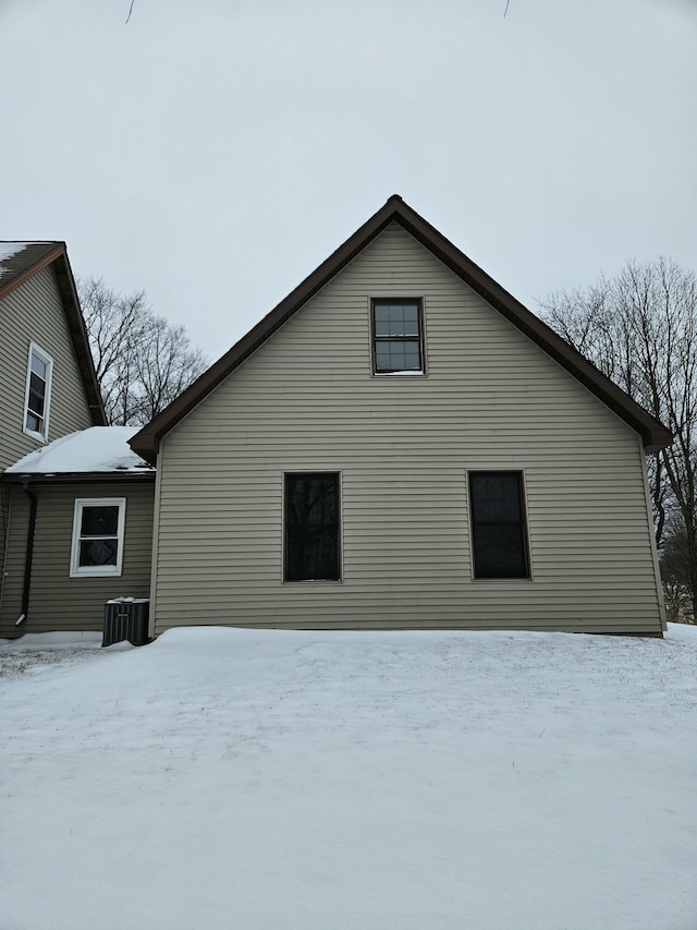 snow covered house featuring central AC