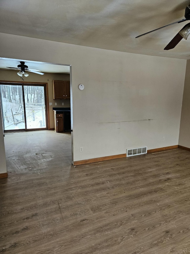 unfurnished living room featuring dark hardwood / wood-style floors and ceiling fan