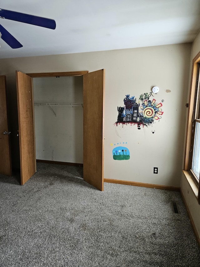 unfurnished bedroom with carpet, ceiling fan, and a closet