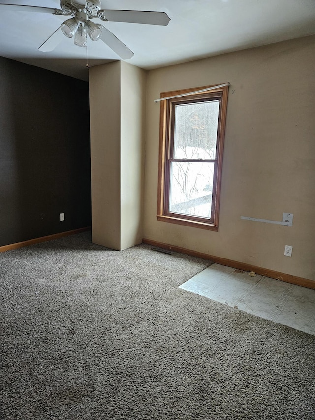 carpeted spare room with ceiling fan