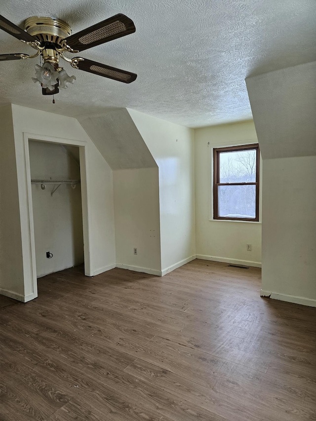 bonus room featuring a textured ceiling, ceiling fan, vaulted ceiling, and hardwood / wood-style flooring