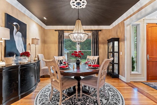 dining space with a wealth of natural light, light hardwood / wood-style flooring, and a notable chandelier