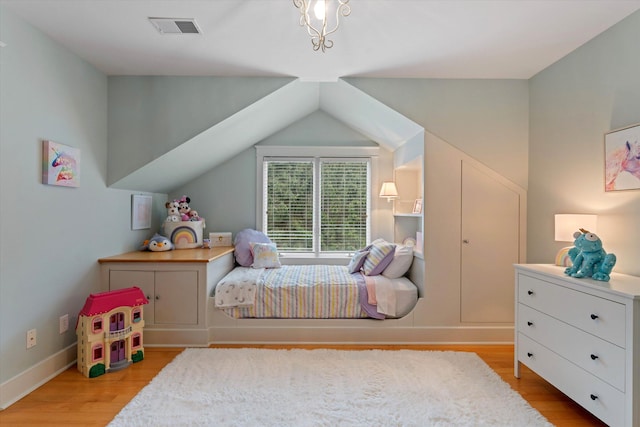 bedroom with vaulted ceiling and light wood-type flooring