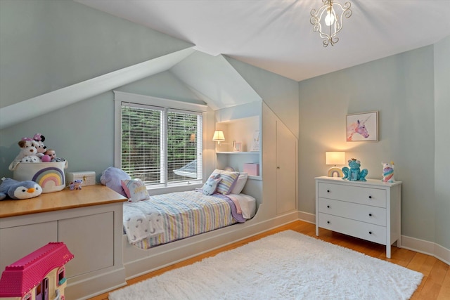 bedroom with light hardwood / wood-style floors and lofted ceiling