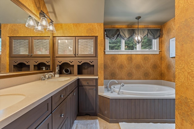 bathroom with tile patterned floors, a bathing tub, and vanity