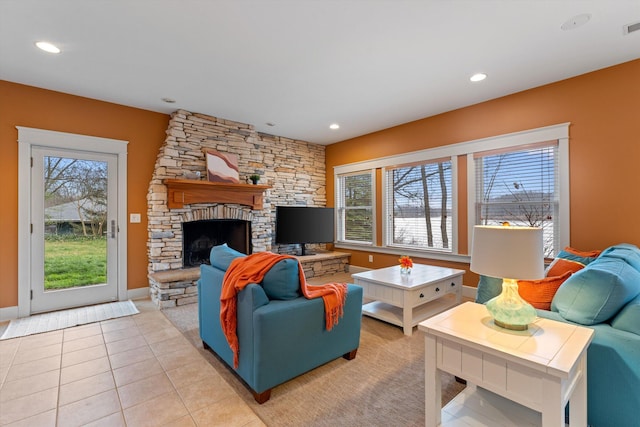 living room with a fireplace and light tile patterned flooring