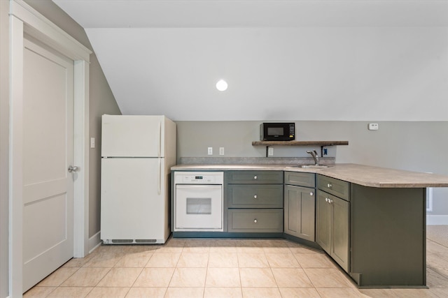 kitchen with lofted ceiling, sink, white appliances, and kitchen peninsula