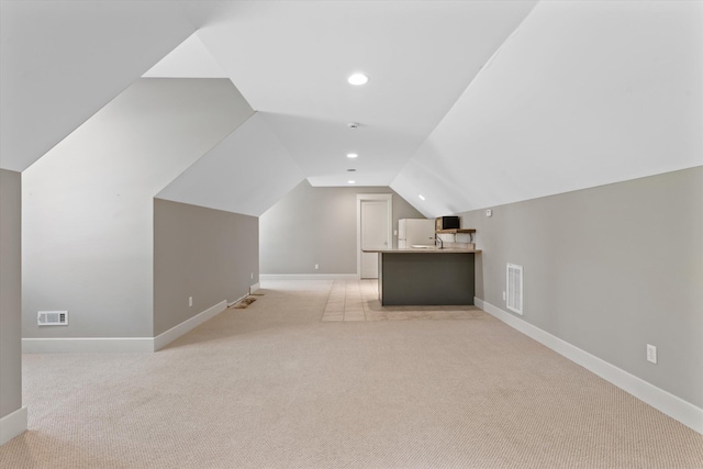 bonus room featuring light colored carpet, lofted ceiling, and sink