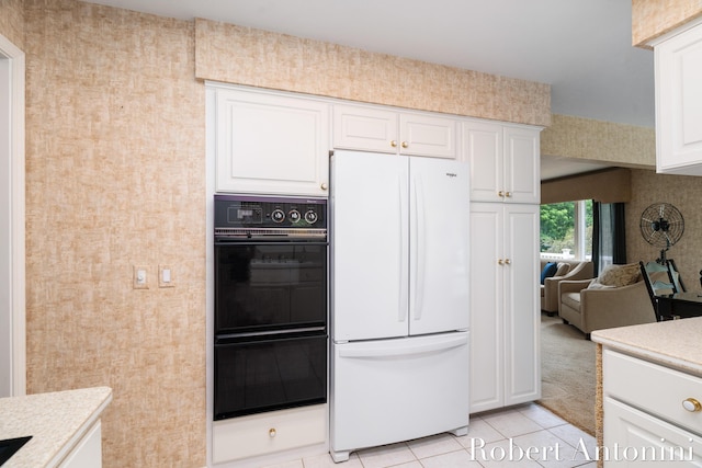 kitchen featuring black double oven, white cabinets, light tile patterned floors, and white fridge