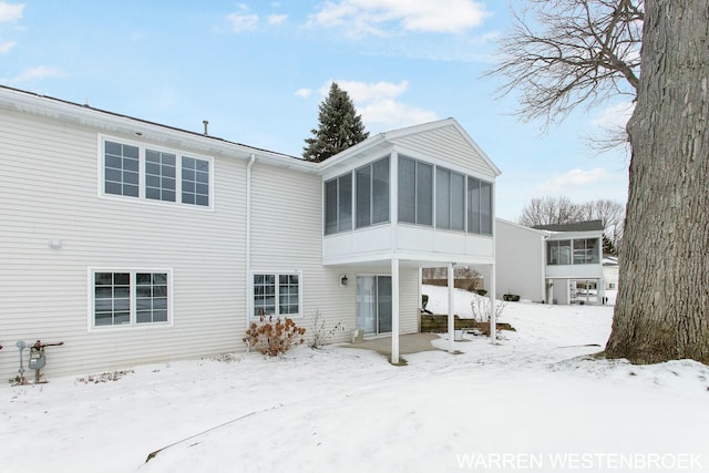 snow covered property featuring a sunroom