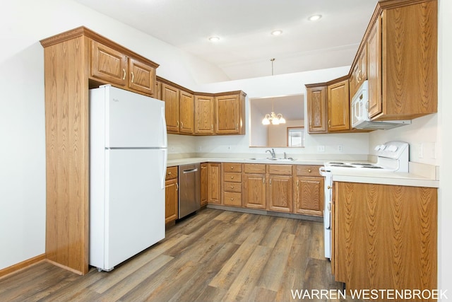 kitchen with sink, hanging light fixtures, dark hardwood / wood-style flooring, a chandelier, and white appliances