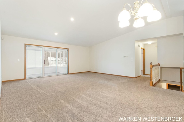 carpeted spare room featuring a chandelier