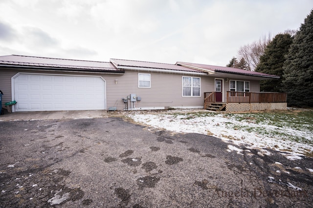 single story home featuring a garage and a deck