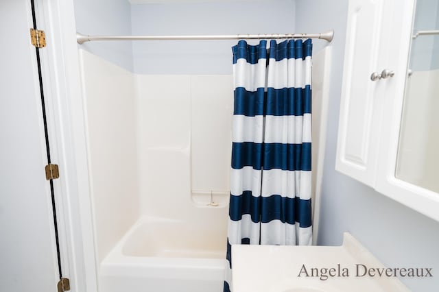 bathroom with shower / tub combo with curtain and vanity