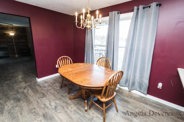 dining room with wood-type flooring, a textured ceiling, and an inviting chandelier