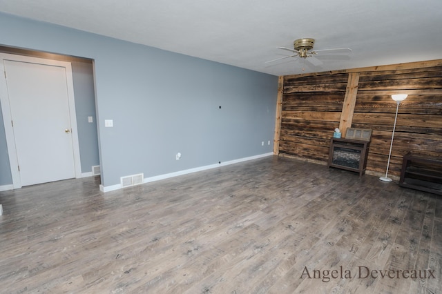 unfurnished living room featuring dark hardwood / wood-style floors and ceiling fan