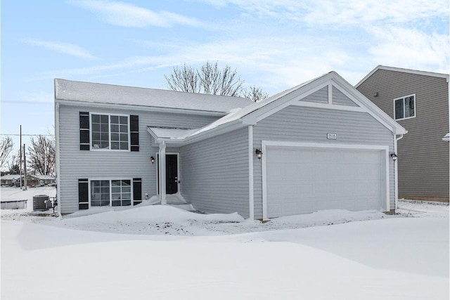 view of front of property with a garage and central air condition unit