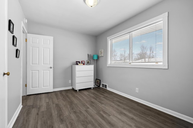 unfurnished bedroom with dark hardwood / wood-style floors