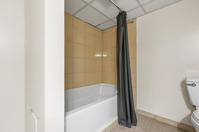 bathroom with shower / bath combination with curtain and toilet