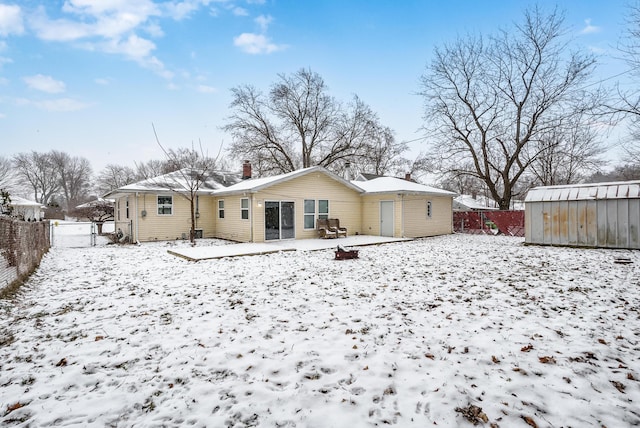 snow covered property featuring a storage unit