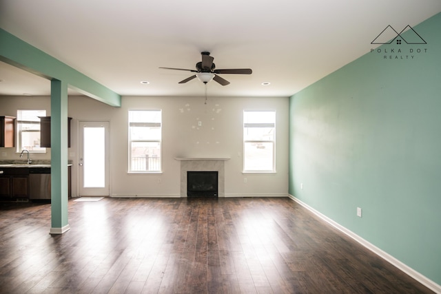 unfurnished living room featuring ceiling fan, wood-type flooring, and sink