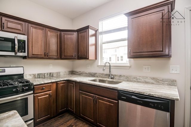 kitchen with dark wood-type flooring, a wealth of natural light, sink, and stainless steel appliances