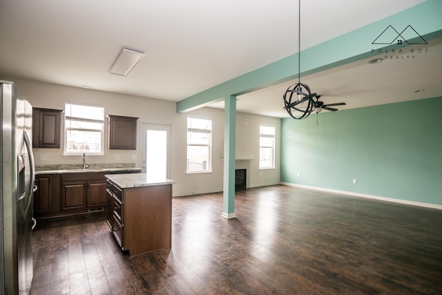 kitchen with ceiling fan, sink, stainless steel fridge with ice dispenser, pendant lighting, and a kitchen island