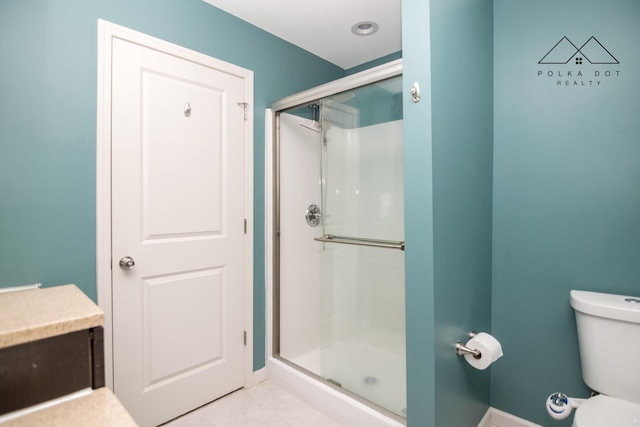 bathroom featuring an enclosed shower, tile patterned flooring, and toilet