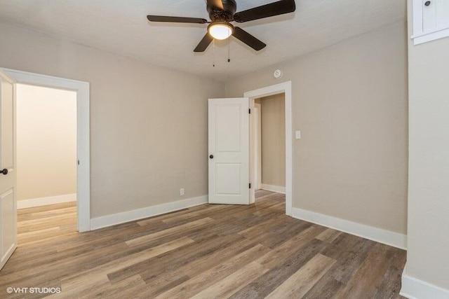 empty room with hardwood / wood-style flooring and ceiling fan